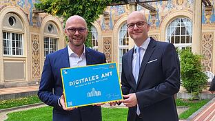 Staatsminister Fabian Mehring (links) mit Bad Kissingens Oberbürgermeister Dirk Vogel bei der Übergabe der Plakette 'Digitales Amt' am 21. Oktober 2024       -  Staatsminister Fabian Mehring (links) mit Bad Kissingens Oberbürgermeister Dirk Vogel bei der Übergabe der Plakette 'Digitales Amt' am 21. Oktober 2024