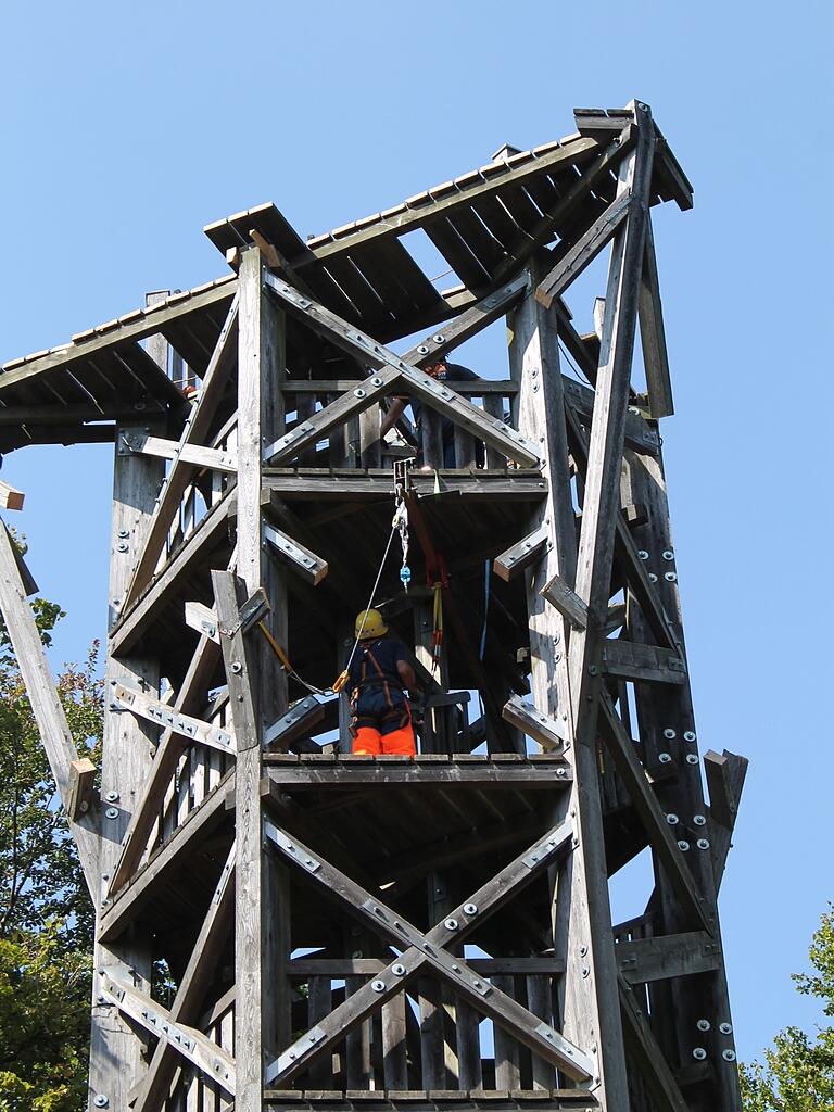 Die Männer, die hoch oben im Turm arbeiten, haben sich an einer Laufkatze eingeklinkt und so gegen Absturz gesichert.