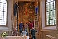 Die Mitglieder der Kirchenverwaltung, des Pfarrgemeinderats und des Küsterteams nehmen das Gemälde in der Unterpleichfelder Kirche von der Wand.