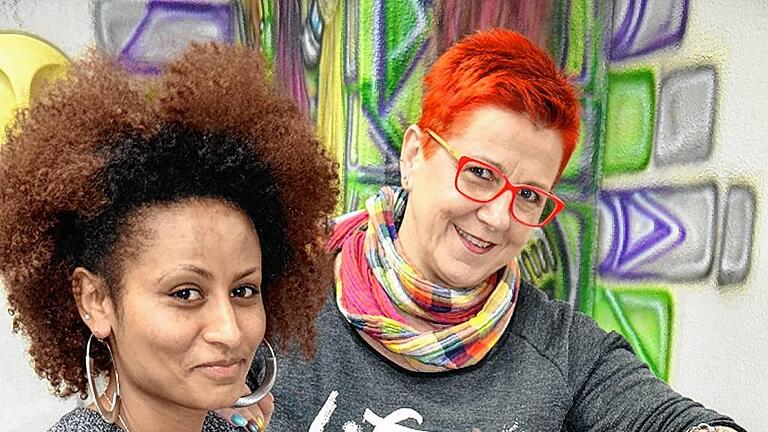 Chefin Elke Kuhn gibt ihrer Auszubildenden Rischan Tipps beim Flechten am Übungskopf.