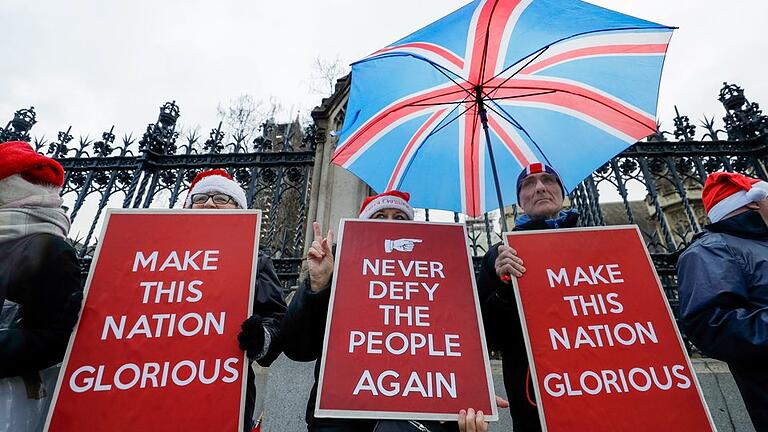 Brexit - Befürworter des Brexit halten Plakate mit den Aufschriften 'Never defy the people again' (Bietet den Bürgern nie wieder die Stirn) und 'Make this nation glorious' (Macht diese Nation prächtig) vor dem britischen Parlament. Brexit - Befürworter des Brexit halten Plakate mit den Aufschriften 'Never defy the people again' (Bietet den Bürgern nie wieder die Stirn) und 'Make this nation glorious' (Macht diese Nation prächtig) vor dem britischen Parlament.