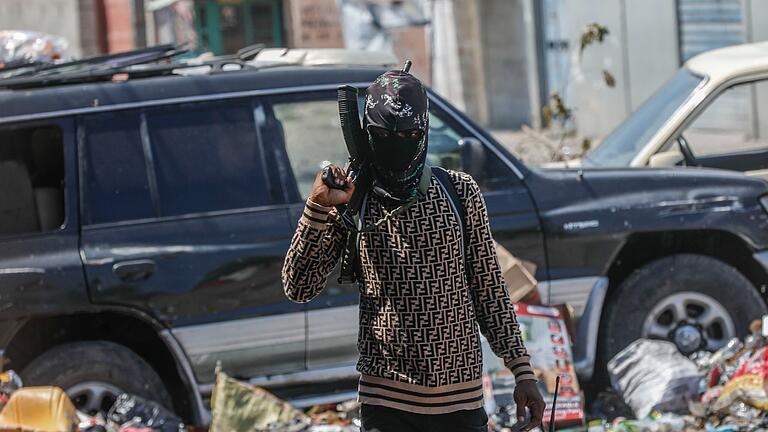 Gewalt in Haiti.jpeg       -  Ein bewaffnetes Mitglied der Bande G9 patrouilliert an einer Straßensperre in Port-au-Prince, Haiti. Mächtige Banden wollen die Macht übernehmen.