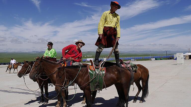 Sattelfest: Mongolische Reiter zeigen bei einem hohen buddhistischen Feiertag nahe Ulan-Bator Kunststückchen.