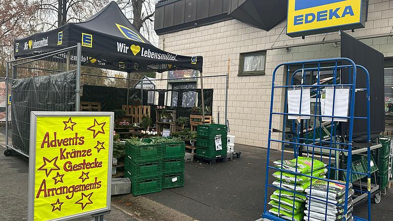 Der dem Blumenladen gegenüberliegende Discounter wirbt für Adventskränze, Gestecke und Arrangements. Der dem Blumenladen gegenüberliegende Discounter wirbt für Adventskränze, Gestecke und Arrangements. 