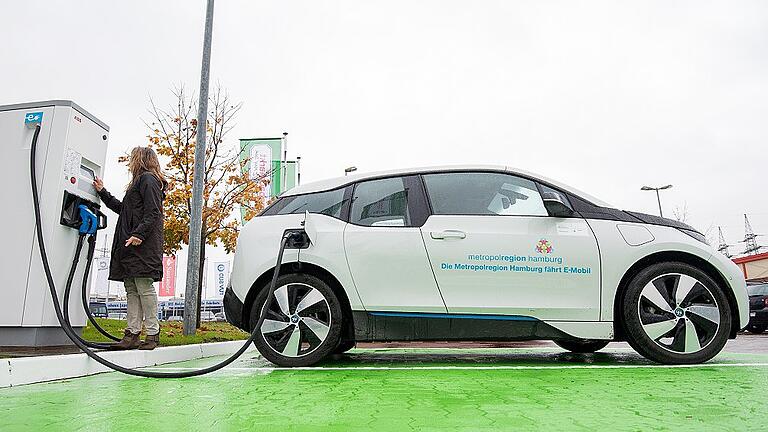 Elektromobilität       -  Eine Frau lädt ein Elektroauto an einer Ladesäule. Die EU will die Pläne für den Aufbau einer Batterie-Fertigung voranbringen. Daniel Bockwoldt, dpa