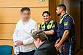 Ein 24-jähriger Mann wird mit Handfesseln in den Gerichtssaal gebracht. Er muss sich wegen versuchter Tötung eines Polizisten und gefährlicher Körperverletzung vor dem Landgericht Würzburg verantworten.