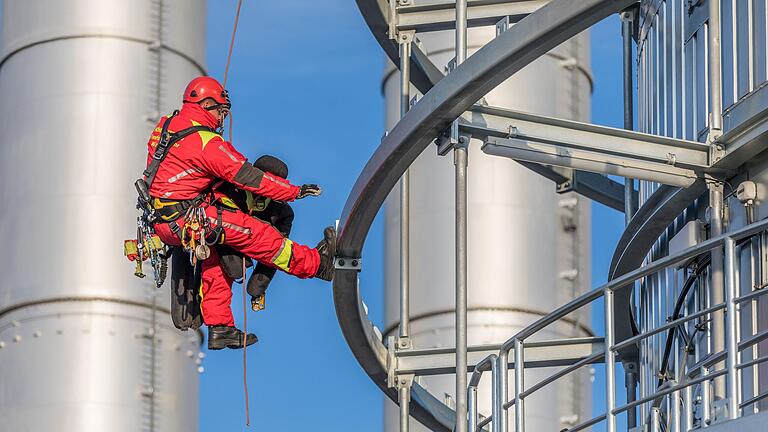 Während eines Übungsszenarios seilt sich ein Höhenretter der Würzburger Berufsfeuerwehr mit einer Übungspuppe am Wärmespeicher des Heizkraftwerks herab.