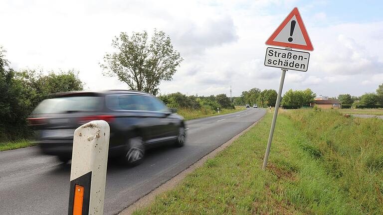 Die Straße zwischen Albertshofen und Kitzingen ist zum Teil völlig kaputt auf und soll seit Jahren saniert werden. Die Frage ist nur: Wer zahlt?