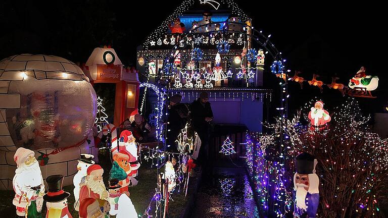 Auch die Fassade des Wohnhauses befindet sich zum Garten hin auf der ganzen Fläche im Lichterglanz, mit Schnee- und Weihnachtsmännern sowie leuchtenden Sternen und Kerzen dekoriert.