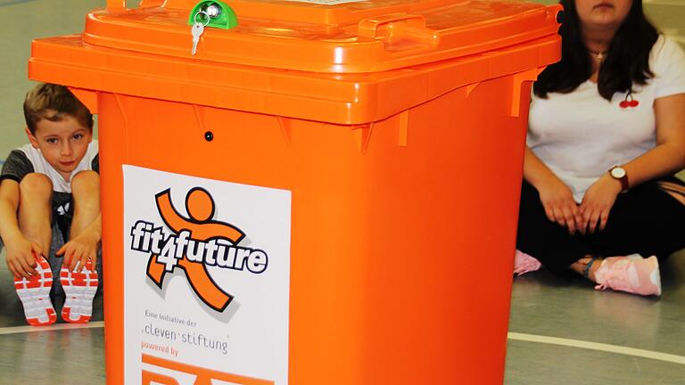 Bis zum Rand vollgestopft mit pädagogisch wertvollen Spiel- und Sportgeräten für Unterricht und Pausen ist diese auffällige, knallorange Tonne, die bei 'fit4future' die Bewegung der Kinder fördern soll. Bis zum Rand vollgestopft mit pädagogisch wertvollen Spiel- und Sportgeräten für Unterricht und Pausen ist diese auffällige, knallorange Tonne, die bei 'fit4future' die Bewegung der Kinder fördern soll.