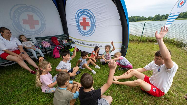 Auftaktveranstaltung Kampagne „Bayern schwimmt“       -  Freiwillige Mitarbeiter der Wasserwacht bringen Kindern zu Beginn der Auftaktveranstaltung der diesjährigen Kampagne &bdquo;Bayern schwimmt&rdquo; am Karlsfelder See das Schwimmen bei.