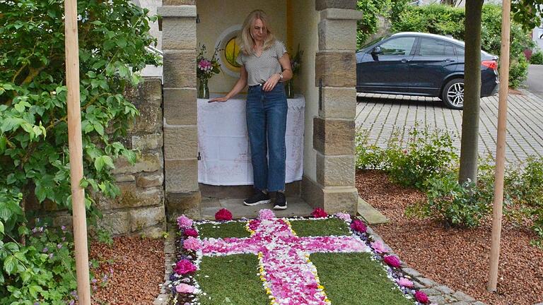 Am Bildstock in Großbardorf wirft Katja Harth noch einmal einen Blick auf den Blütenteppich, bringt Blumen zum Altar, bevor dort der historische Hausaltar aufgestellt wird.