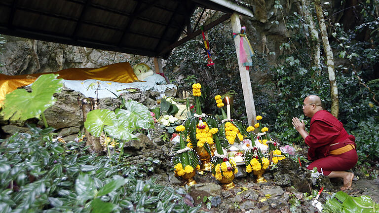 Fußballmannschaft in Thailand in Höhle eingeschlossen       -  Ein buddhistischer Mönch betet an einem Schrein Nahe der Höhle.