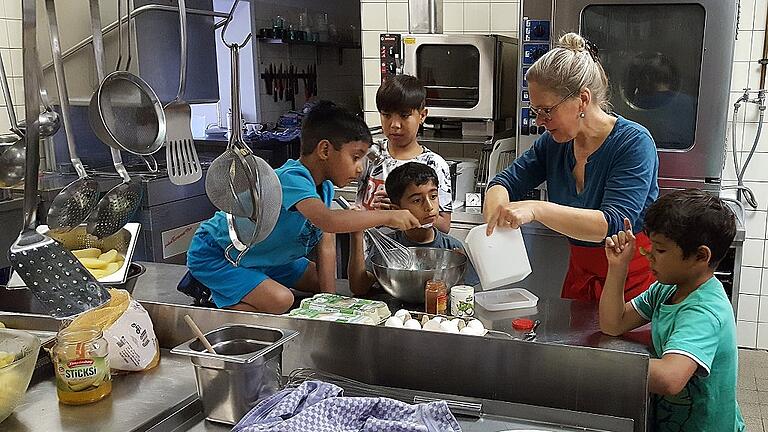 Gemeinsames Kochen bei der Familienfreizeit: Monika Hoffmann vom Freundeskreis Asyl zusammen mit Flüchtlingskindern. Gemeinsames Kochen bei der Familienfreizeit: Monika Hoffmann vom Freundeskreis Asyl zusammen mit Flüchtlingskindern.