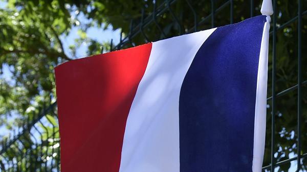 FRANCE-ATTACK       -  Eine französische Flagge und Blumen am Zaun der Firma Air Products nahe Lyon. Hier führte der 35-jährige Yassin S. seinen Anschlag aus.