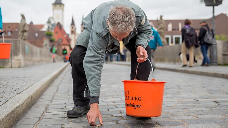 Stephen Wehner vom Bergwaldprojekt e.V. hebt einen Zigarettenstummel vom Boden auf. Rund 100 Helfer beteiligten sich an der öffentlichen Müllsammelaktion seines Vereins.