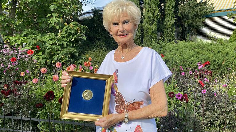 Gisela Götz, die Tochter von Wilhelm 'Willi' Menne, mit der Goldmedaille ihres Vaters von den Olympischen Spielen 1936 in Berlin.