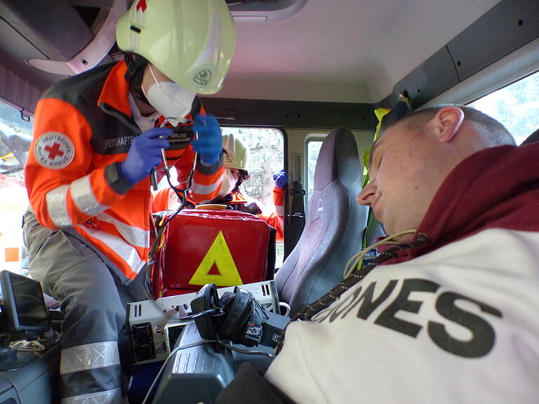 Zwei Sanitäter kümmern sich um den bewußtlosen Fahrer in der engen Fahrerkabine. Zwei Sanitäter kümmern sich um den bewußtlosen Fahrer in der engen Fahrerkabine.