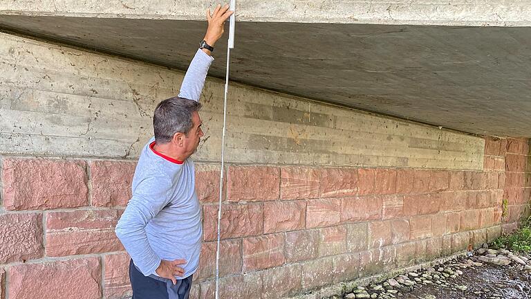 Ein Mitarbeiter des Landratsamtes beobachtet die Niedrigwassersituation an einem Gewässer im Main-Tauber-Kreis: Das Landratsamt weist darauf hin, dass aus oberirdischen Gewässern nur begrenzt Wasser entnommen werden darf.