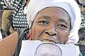 Jubel: Eine Unterstützerin von Uhuru Kenyatta (auf dem Plakat) feiert, dass es nun doch keinen Prozess gegen ihn gibt.