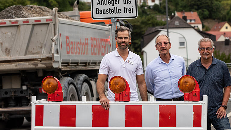 Drei von 32 Geschäftsleuten in Versbach und Rimpar, die wegen der Sperrung um ihre Umsätze fürchten: (von links) Andreas Dömling (Apotheker), Peter Friedel (Optiker) und Peter Götz (Sport und Mode) stehen an der Absperrung. Foto: Patty Varasano