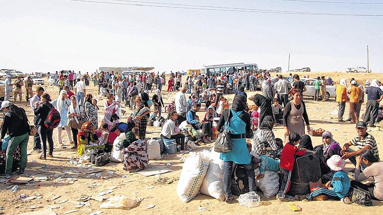 Warten an der Grenze: Syrische Flüchtlinge am Grenzpunkt in Duhuk wollen in den Irak einreisen. Warten an der Grenze: Syrische Flüchtlinge am Grenzpunkt in Duhuk wollen in den Irak einreisen.
