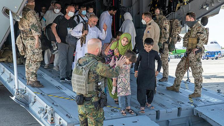 In Taschkent (Usbekistan) werden aus Afghanistan evakuierte Menschen von deutschen Sicherungskräften aus einem Airbus geleitet. Nach der Machtübernahme der Taliban in Afghanistan hat die Bundeswehr unter schwierigsten Bedingungen eine Luftbrücke zur Evakuierung von Deutschen und Afghanen eingerichtet.