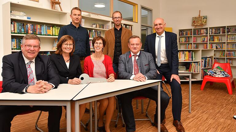 Gemeinsam mit Rektorin Barbara Bartsch (Mitte) drücken Landtagsabgeordneter Volkmar Halbleib (links), stellvertretende Landrätin Karen Heußner und Landtagsabgeordneter Manfred Ländner im neuen Erweiterungsbau der Giebelstadter Grundschule die Schulbank. Auf dem Bild dabei sind (hinten von links) Helge Bey und Jürgen Schrauth vom Architekturbüro Haase &amp; Bey sowie Bürgermeister Helmut Krämer. Foto: Gerhard Meißner