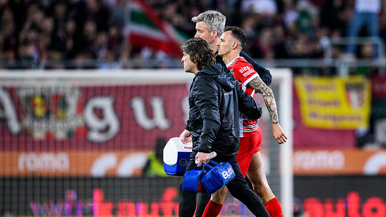 FC Augsburg - VfB Stuttgart.jpeg       -  FCA-Verteidiger Iago musste am Freitagabend verletzt von Mannschaftsarzt Dr. Andreas Weigel (vorne) und Physiotherapeut Niklas Albers vom Spielfeld geführt werden.