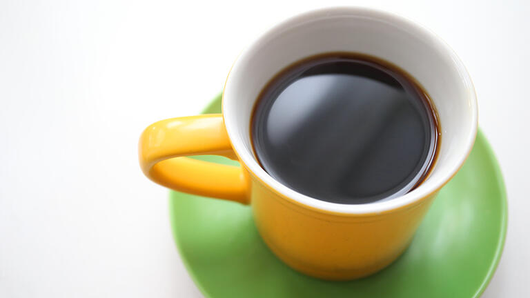 Schwarz, Gelb und Grün am Frühstückstisch       -  ARCHIV - ILLUSTRATION - Eine gelbe Tasse mit schwarzem Kaffee steht am 20.11.2017 in Kempten (Bayern) auf einem grünen Unterteller (Illustration Jamaika-Koalition).
