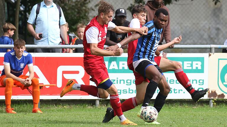 Mario Paul (links) und Sebastian Dlab vom SSV Kitzingen versuchen, Stürmer Osakpolor Iyore (rechts) von der TG Höchberg zu stoppen. Beide Mannschaften trennten sich 3:3. Sowohl Paul als auch Iyore trafen für ihre Teams. Mario Paul (links) und Sebastian Dlab vom SSV Kitzingen versuchen, Stürmer Osakpolor Iyore (rechts) von der TG Höchberg zu stoppen. Beide Mannschaften trennten sich 3:3. Sowohl Paul als auch Iyore trafen für ihre Teams.