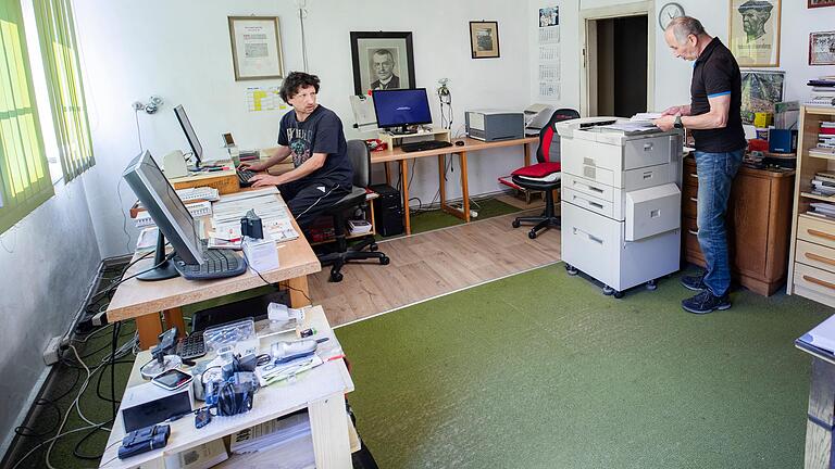 In der ehemaligen Wohnung der Großeltern im ersten Stock der Druckerei baut Jörg Gunzenheimer (links) die 'Ostheimer Zeitung' am Computer zusammen.