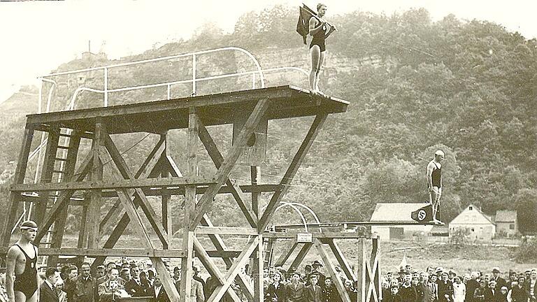 Das Karlstadter Freibad wurde am&nbsp;12.&nbsp;Juni&nbsp;1938 eröffnet. Sportler mit Hakenkreuz-Fahnen stürzten sich von den Sprungtürmen in die Fluten. Am&nbsp;Pult ist Bürgermeister&nbsp;Friedrich&nbsp;Held.