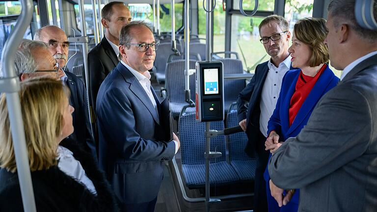 Wirtschaftsstandort Schweinfurt: Alexander Dobrindt, CSU-Landesgruppenchef im Bundestag (Fünfter von links) lässt sich in einem Elektrobus der Schweinfurter Stadtwerke erklären, wie das bargeld- und papierlose Ticket funktioniert.