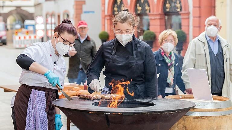 Die Auszubildenden der 'Schwane' in Volkach bereiten an einem To-go-Stand vor dem Restaurant Bratwürste am Grill zu. Für die angehenden Köchinnen Lisa Kozilek und Julia Andres ist es eine von wenigen Möglichkeiten, in der Corona-Zeit auch praktisch zu arbeiten. Die Auszubildenden der 'Schwane' in Volkach bereiten an einem To-go-Stand vor dem Restaurant Bratwürste am Grill zu. Für die angehenden Köchinnen Lisa Kozilek und Julia Andres ist es eine von wenigen Möglichkeiten, in der Corona-Zeit auch praktisch zu arbeiten.