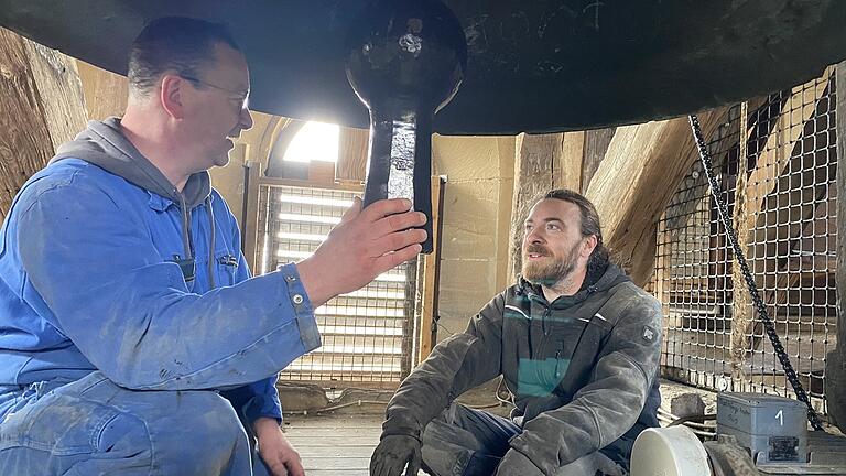 Glockengießermeister Rudolf Perner (links) und Bautechniker Simon Lang beim Einbau des neuen Klöppels der Marien-Glocke.