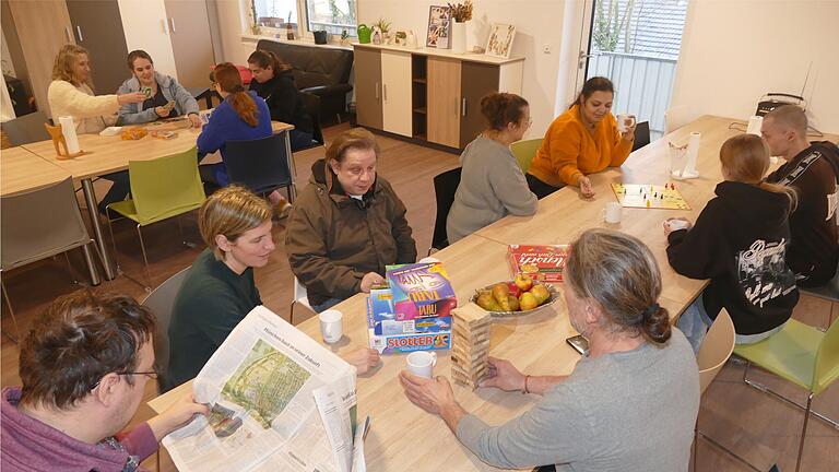 Bei einem Spielenachmittag sitzen Besuchende in der Tagesstätte 'Miteinander' im Johanna-Kirchner-Haus zusammen. Das Mobiliar entstand weitgehend in der heimeigenen Schreinerwerkstatt. Bei einem Spielenachmittag sitzen Besuchende in der Tagesstätte 'Miteinander' im Johanna-Kirchner-Haus zusammen. Das Mobiliar entstand weitgehend in der heimeigenen Schreinerwerkstatt.
