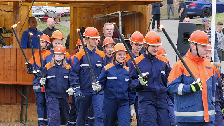 Das Entzünden des Lagerfeuers mit Fackeln gehört mit zur Eröffnungsfeier des Feuerwehr-Zeltlagers.