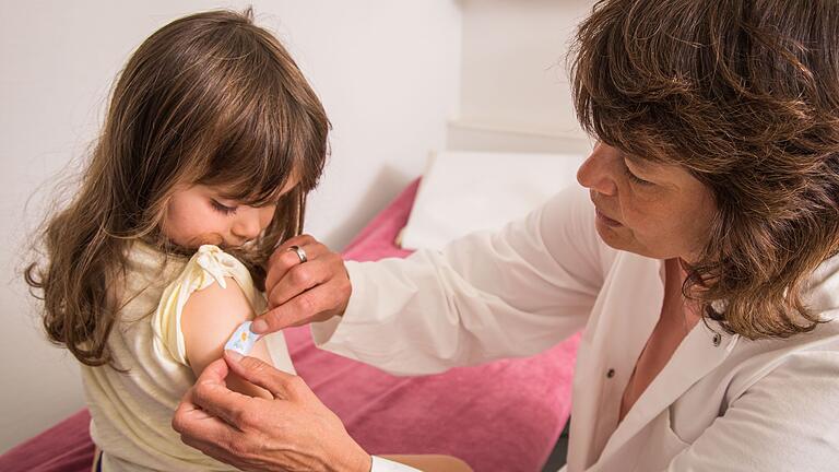 Mädchen bekommt beim Kinderarzt ein Pflaster auf den Arm       -  Auch Kinder brauchen schon eine Diphtherie-Auffrischung. Die erste ist der Stiko-Empfehlung zufolge im Alter von fünf bis sechs Jahren dran.