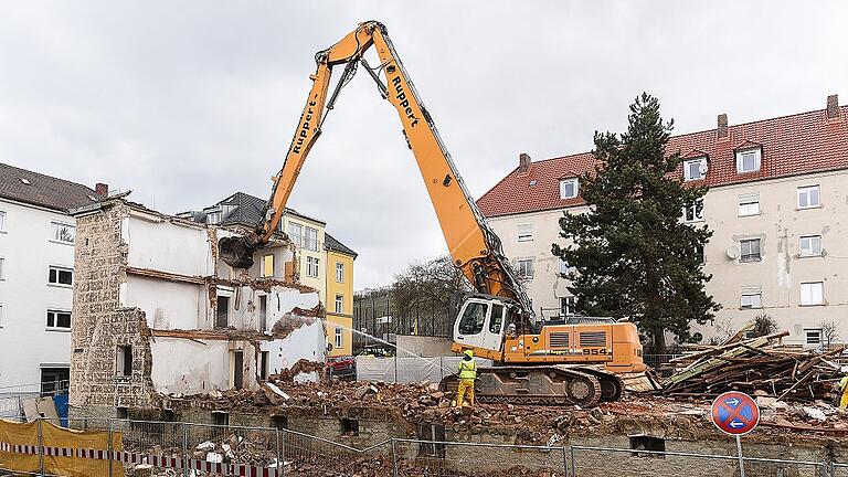 Mit einem großen Spezialbagger werden derzeit zwischen der Steinheil- und der Schiestlstraße in Grombühl 65 Jahre alte Stadtbauhäuser abgerissen. Dort soll das Bossiviertel, benannt nach einer benachbarten Straße, entstehen.