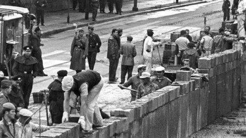 60 Jahre Bundesrepublik - Mauerbau       -  ARCHIV - Unter der Aufsicht von bewaffneten Volkspolizisten errichtet eine Ostberliner Maurerkolonne am 18.8.1961 an der sowjetisch-amerikanischen Sektorengenze am Potsdamer Platz eine mannshohe Mauer. Am 13. August begann es.