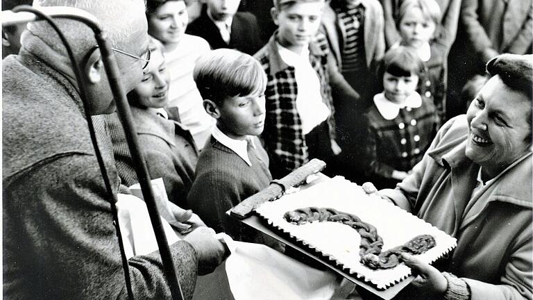 In den 50er-Jahren: Der Zweite Bürgermeister überreicht die historische Pranger-Kette am Zeiler Rathaus als Gebäck an eine junge Besuchergruppe. Anmerkung der Redaktion: Trotz sorgfältiger Recherche konnte der Rechteinhaber dieses Fotos nicht ermittelt werden. Rechteinhaber werden gebeten, sich bei der Redaktion zu melden.