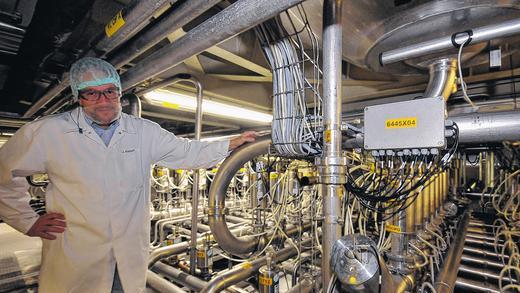 Molkereileiter Johannes Kogut unter den Fermentern, in denen die Milch zu Joghurt wird. Penible Sauberkeit und Schutzkleidung sorgen dafür, dass keine fremden Keime in den Produktionsbereich gelangen.