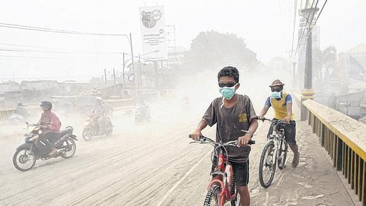 Überall Asche: Menschen auf einer Straße im indonesischen Yogyakarta.