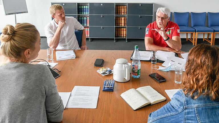 Steffen Liebler (links) und Roland Sauer (rechts) erklären den Sport-Redakteurinnen Carolin Münzel (links) und Natalie Greß (rechts) im Interview, wie ein Spielbetrieb mit Zuschauern in der s.Oliver Arena aussehen kann.