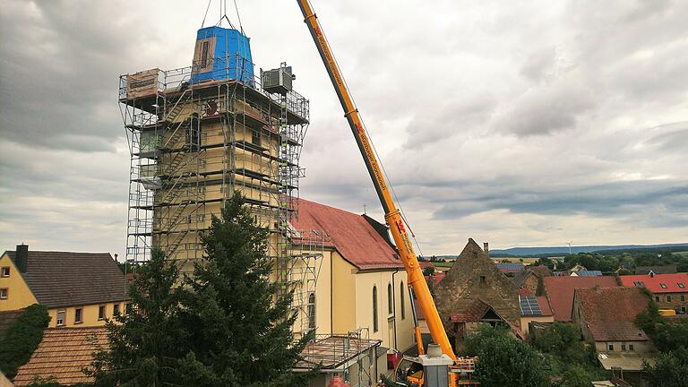 Ein Kran hob den ersten Teil des neuen Turmhelms wieder auf den Kirchturm in Stadelschwarzach. Bei einem Sturm wurde sie quasi davon geblasen.