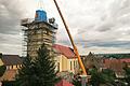 Ein Kran hob den ersten Teil des neuen Turmhelms wieder auf den Kirchturm in Stadelschwarzach. Bei einem Sturm wurde sie quasi davon geblasen.