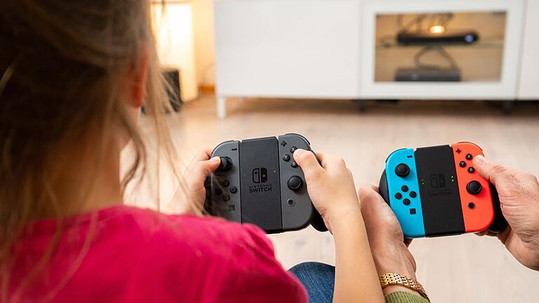 Spielende halten bunte Controller in der Hand.jpeg       -  Hat die Nintendo Switch bald ausgedient? Gerüchten zufolge soll Nintendo bereits an einem Nachfolger arbeiten. Was bislang bekannt ist.