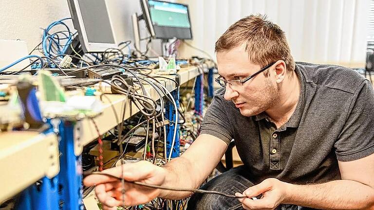 Testingenieur Maximilian Palka verkabelt Geräte, auf denen die Navigationssysteme von Garmin Würzburg in allen Funktionen getestet werden. Testingenieur Maximilian Palka verkabelt Geräte, auf denen die Navigationssysteme von Garmin Würzburg in allen Funktionen getestet werden.