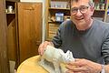 Wolfgang Domes, Kirchenmaler und Restaurator aus Frickenhausen, hält ein Nashorn, das zerbrochen war.